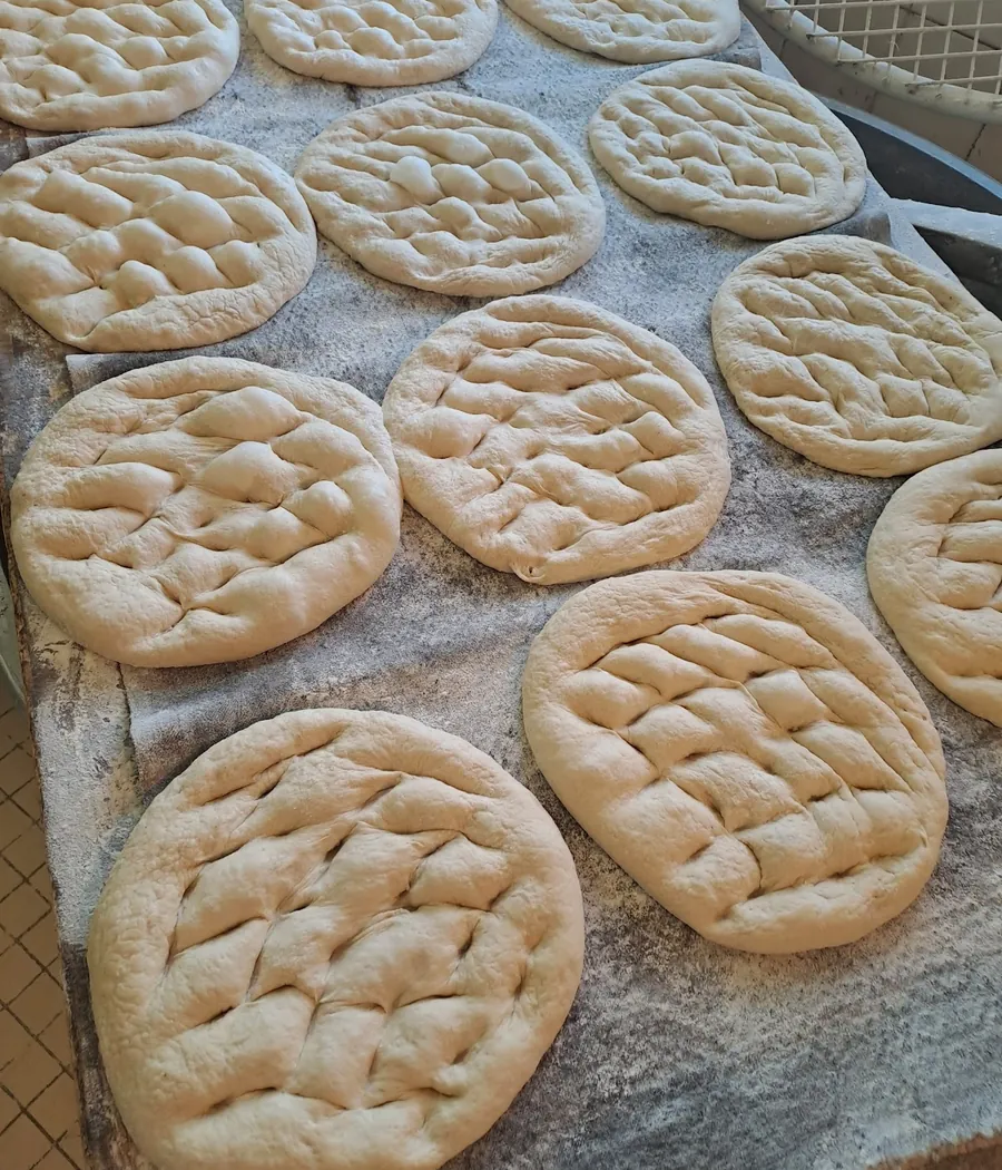 Galettes rondes et dorées posées sur une plaque farinée